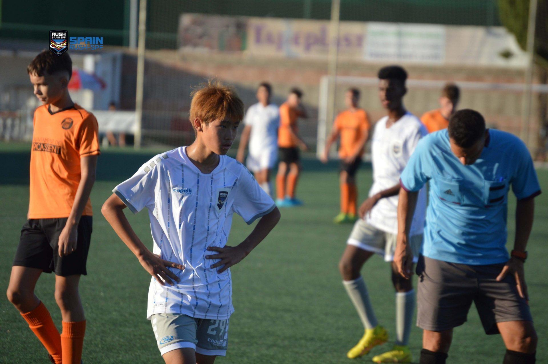 A group of young men are playing soccer on a field.