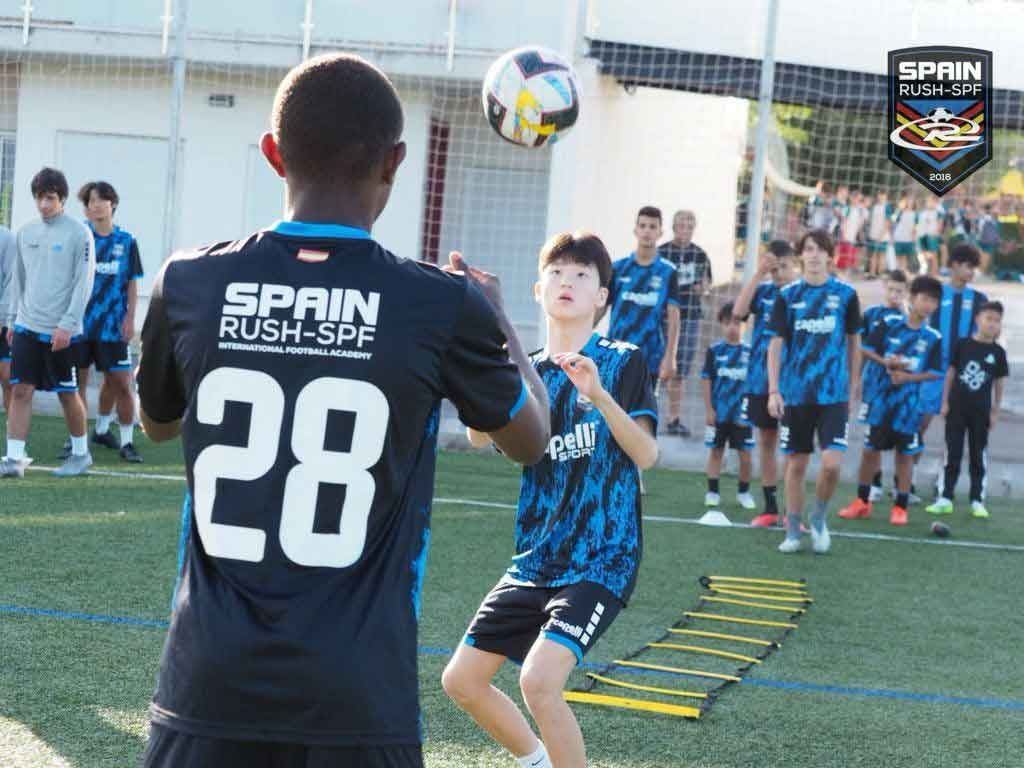 A group of young boys are practicing soccer on a field.