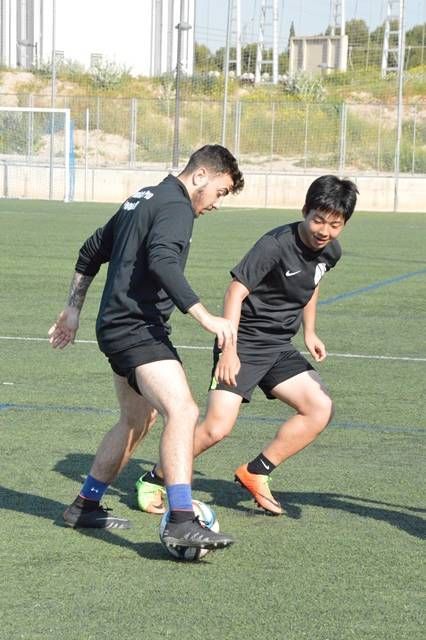 Two men are playing soccer on a field and one has the number 9 on his shirt