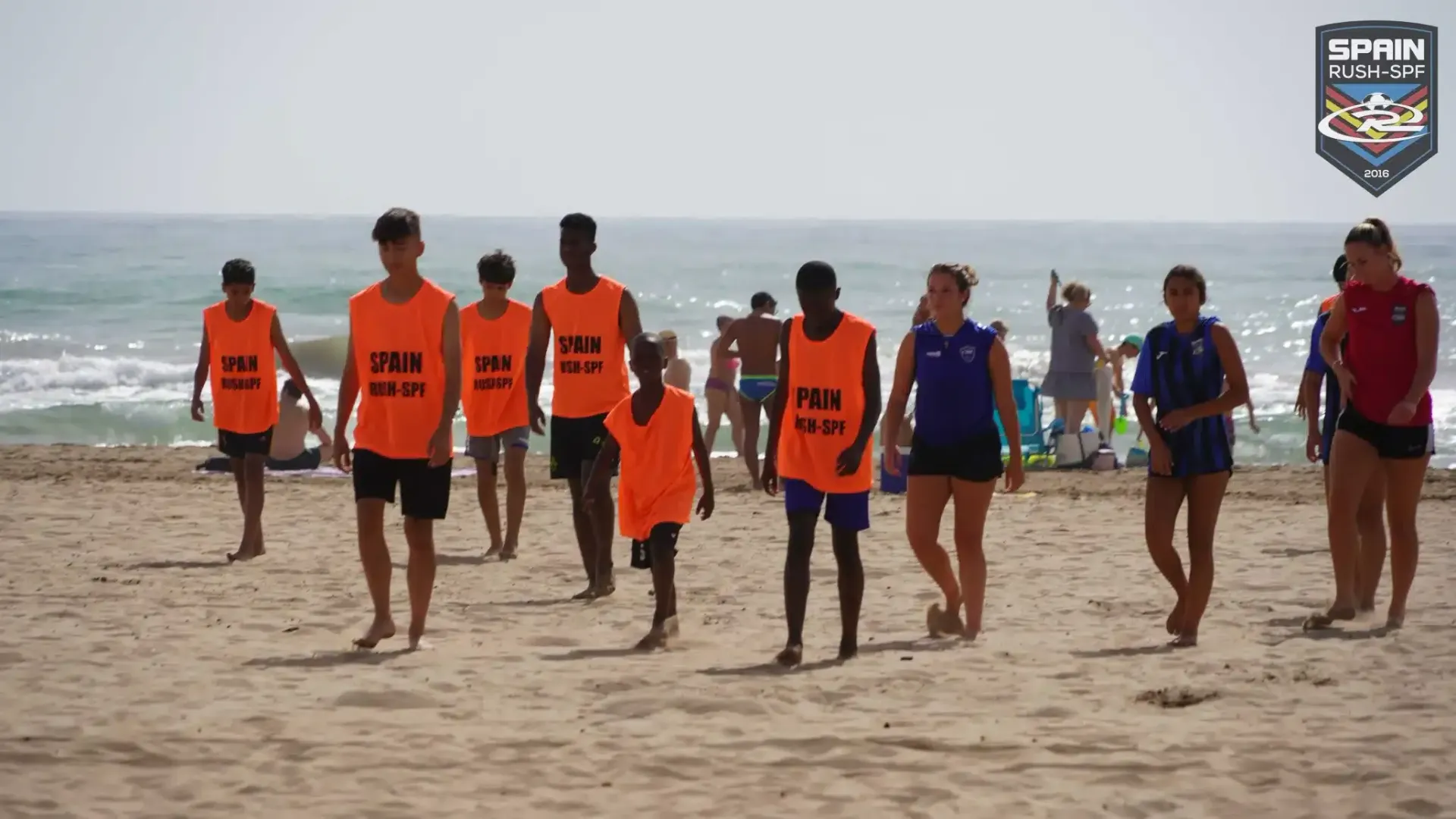 A group of people are walking on a beach.
