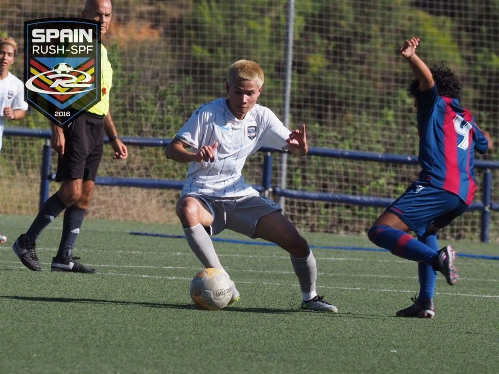 A group of soccer players are playing a game on a field.