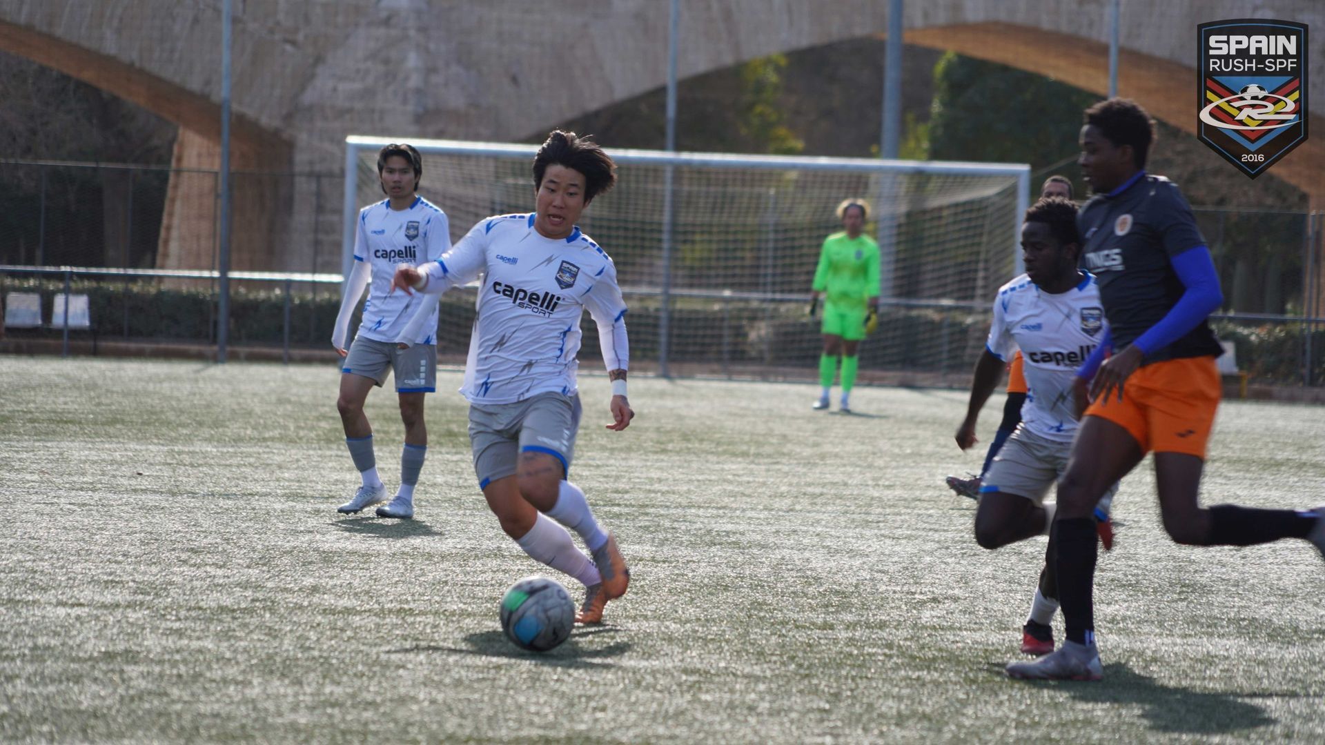 A group of young men are playing soccer on a field.