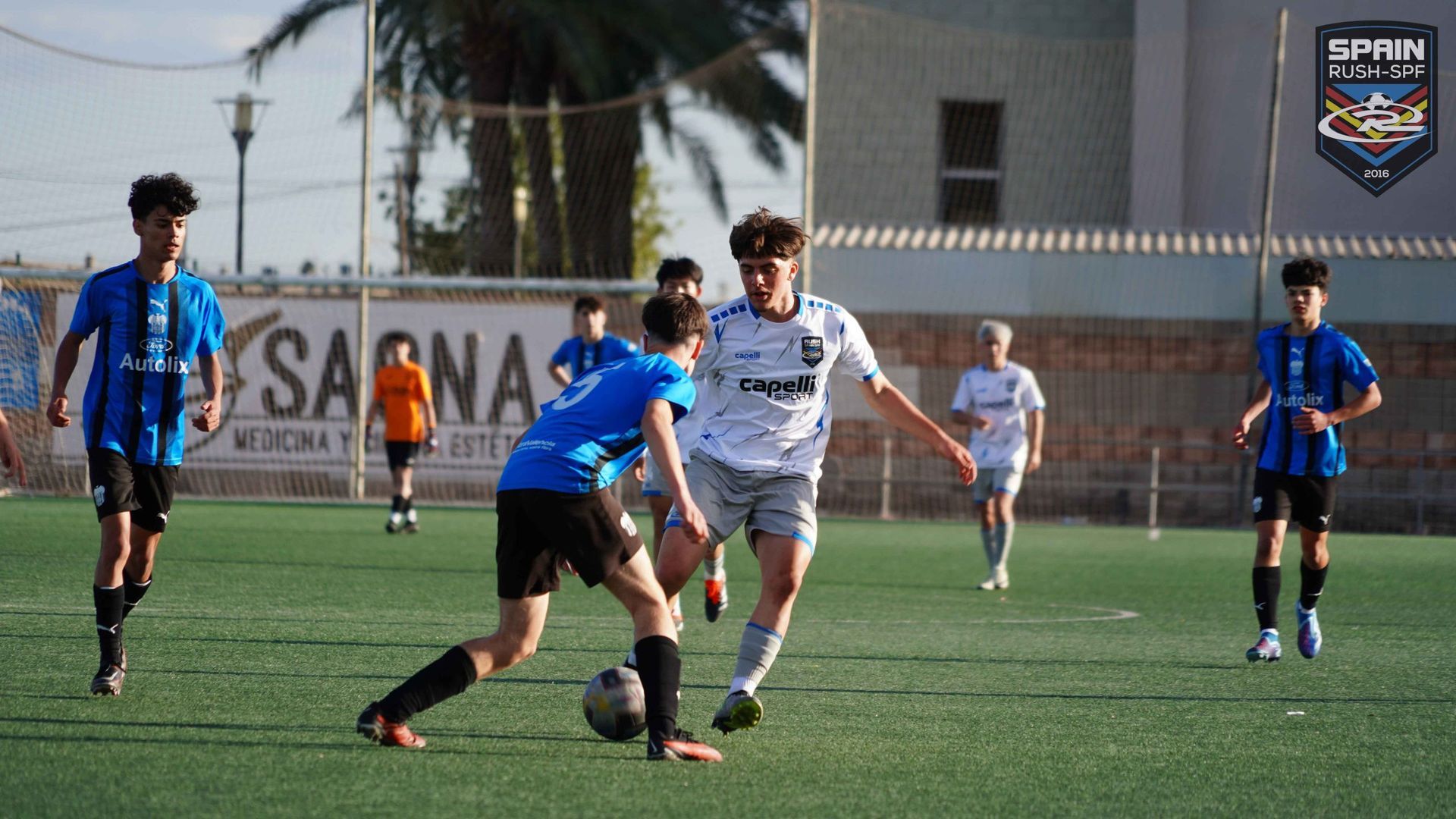 A group of young men are playing soccer on a field.