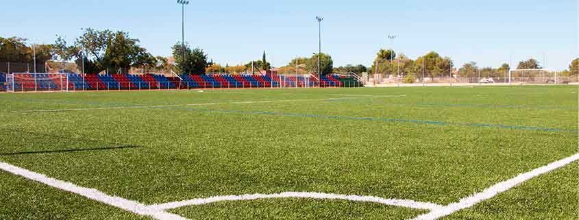 A soccer field with a white line on the corner.