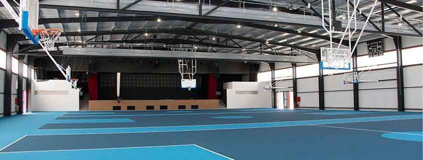 There is a basketball hoop in the middle of the gym.