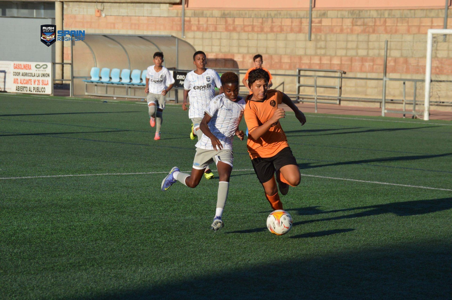 A group of young men are playing soccer on a field.