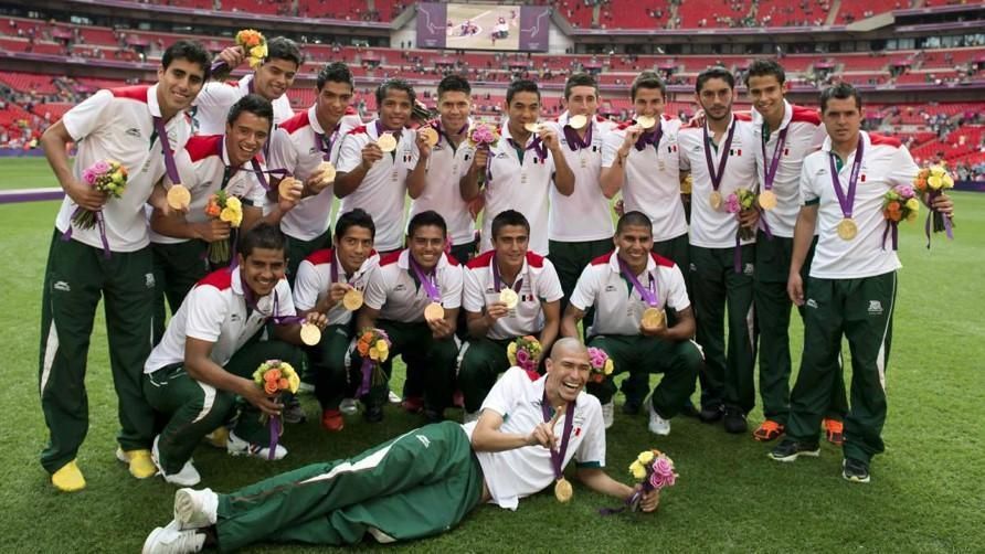 A group of athletes posing for a picture with medals