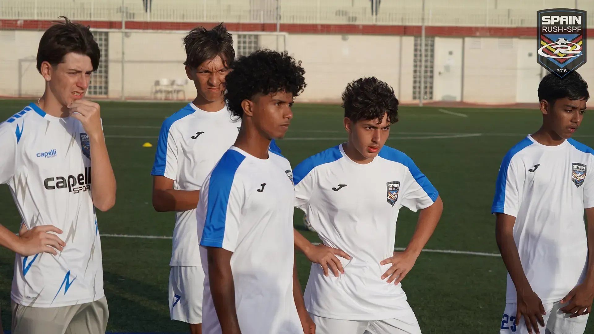 A group of young men are standing on a soccer field.