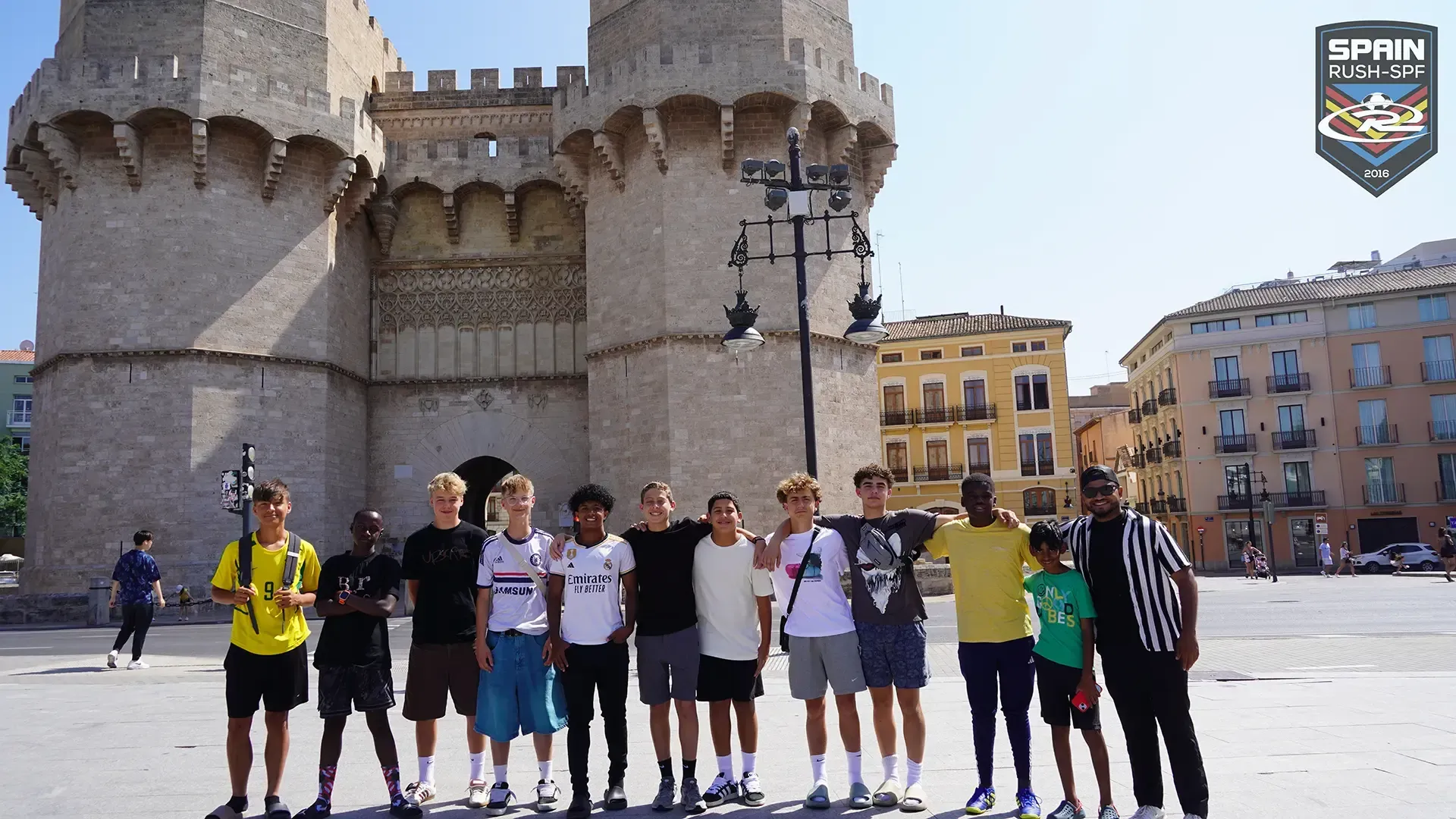 A group of soccer players are posing for a picture in front of a castle.