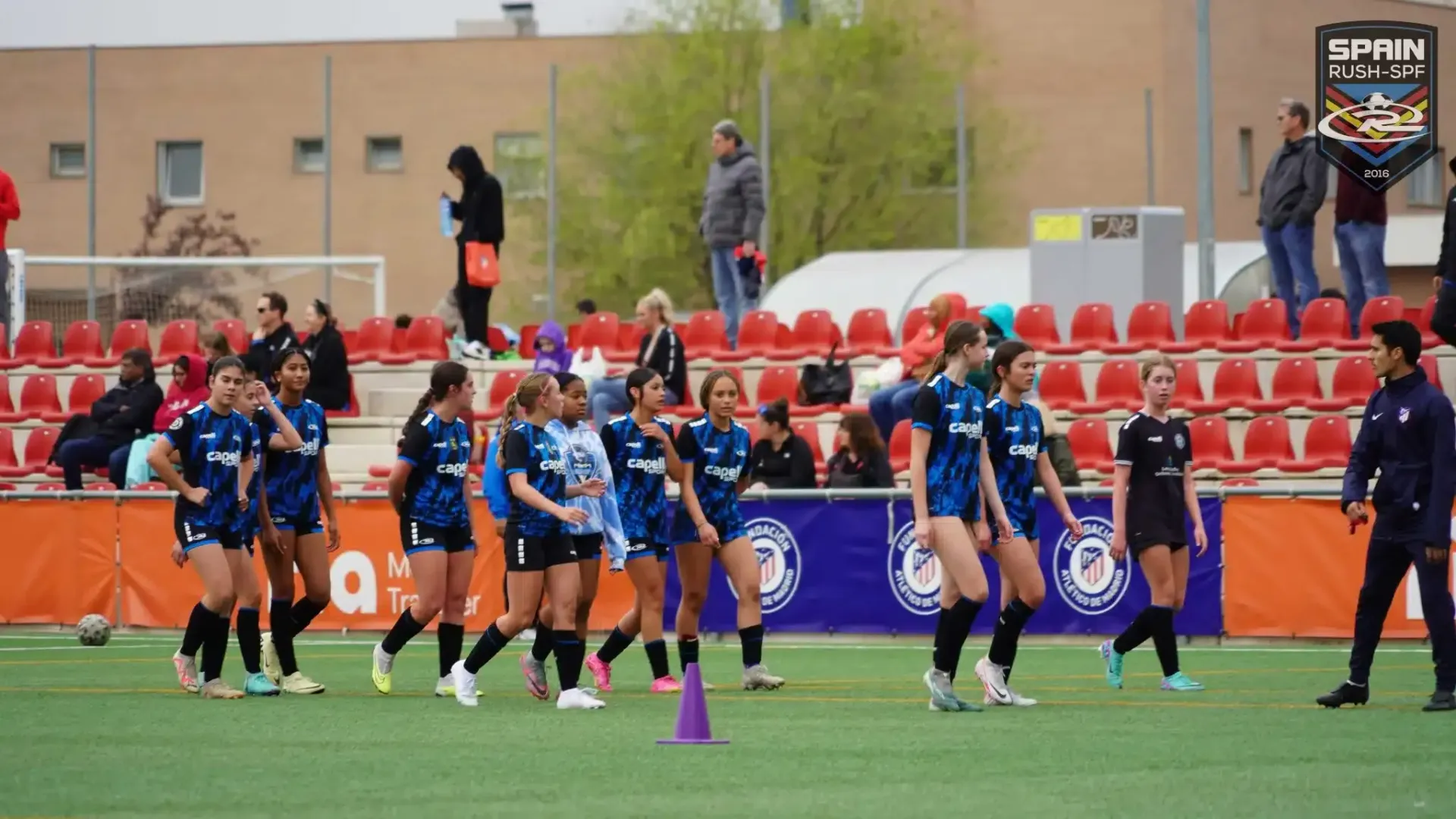 A group of young female soccer players from Spain Rush-SPF, walking on the field during training 