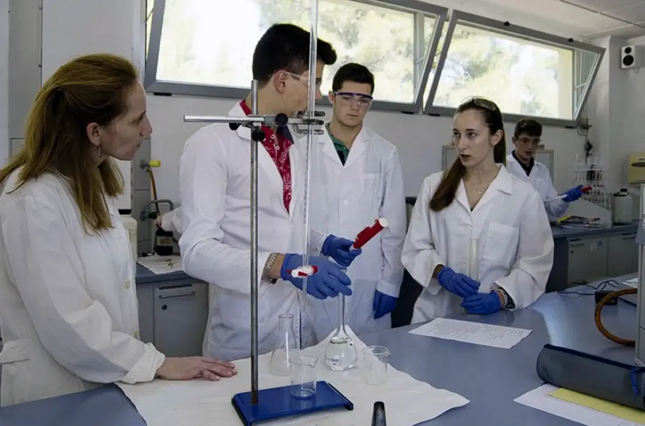 A group of people are standing around a table in a lab.