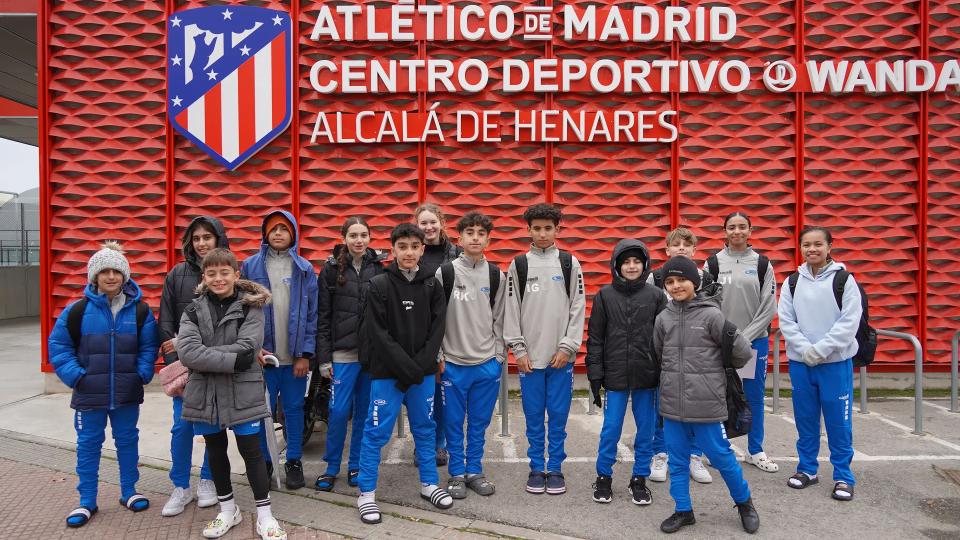 A group of children are posing for a picture in front of a building.