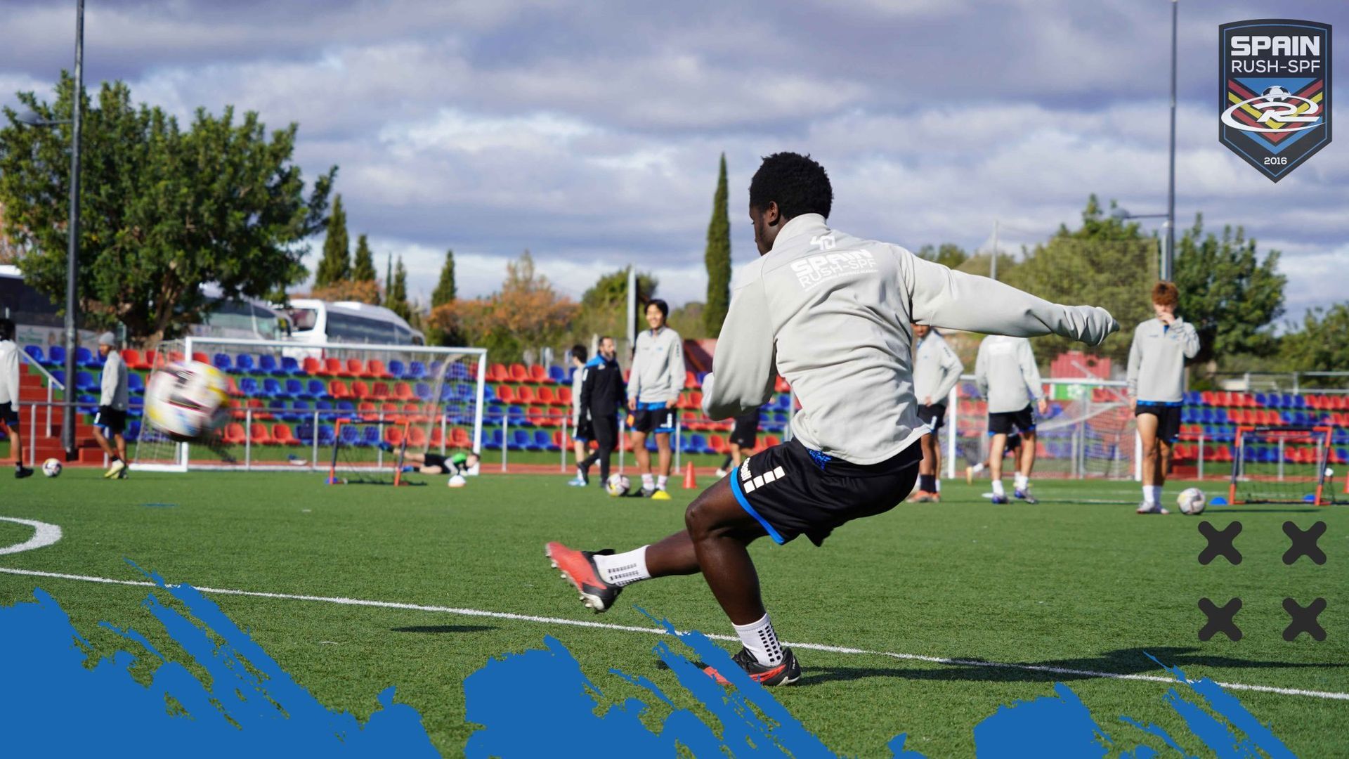 A man is kicking a soccer ball on a field.