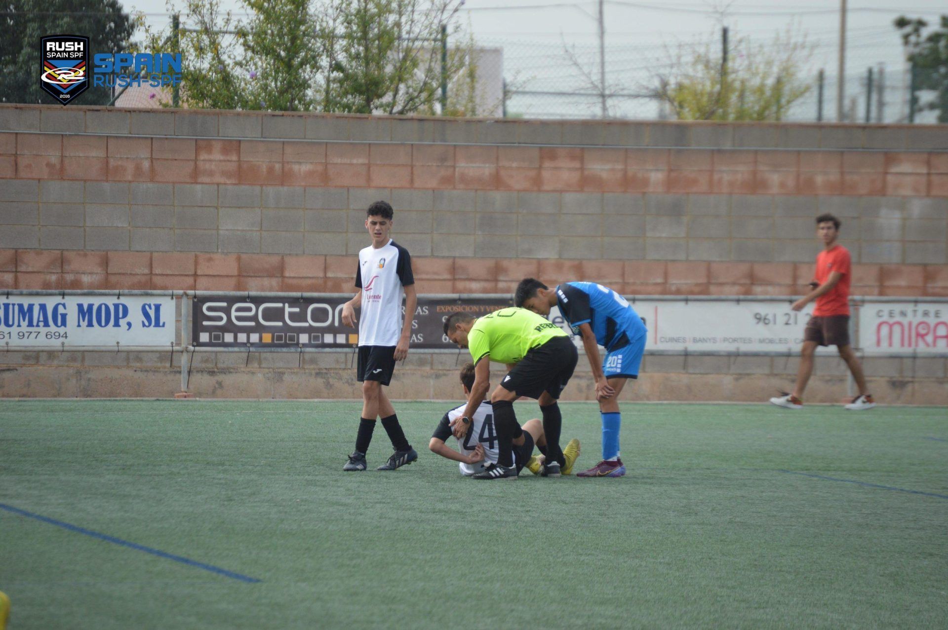 A group of soccer players are playing a game on a field.