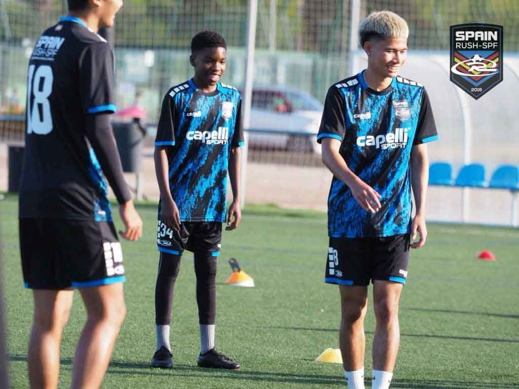 A group of young men are playing soccer on a field.