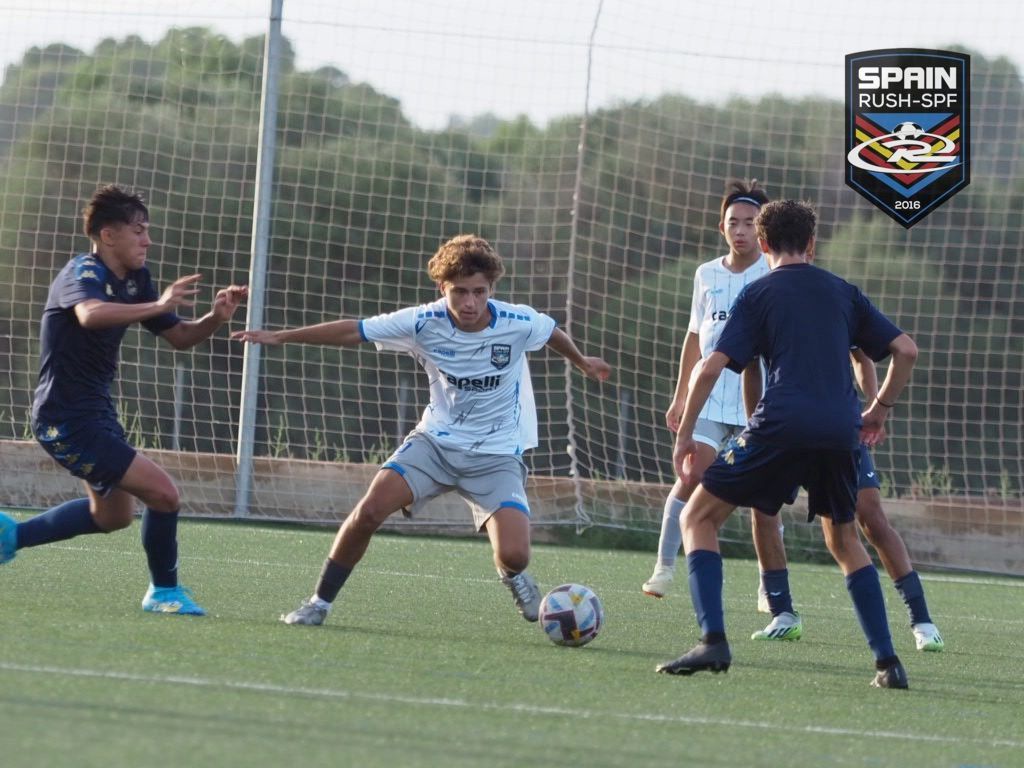 A group of young men are playing soccer on a field.