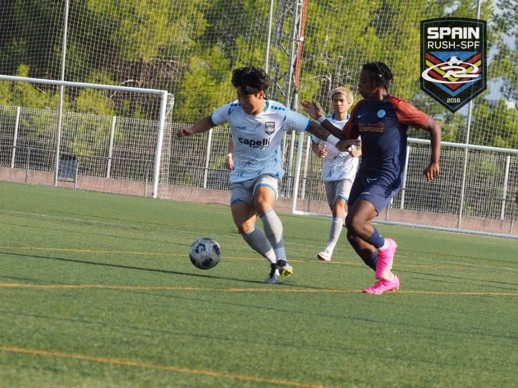 Two young men playing soccer on a field