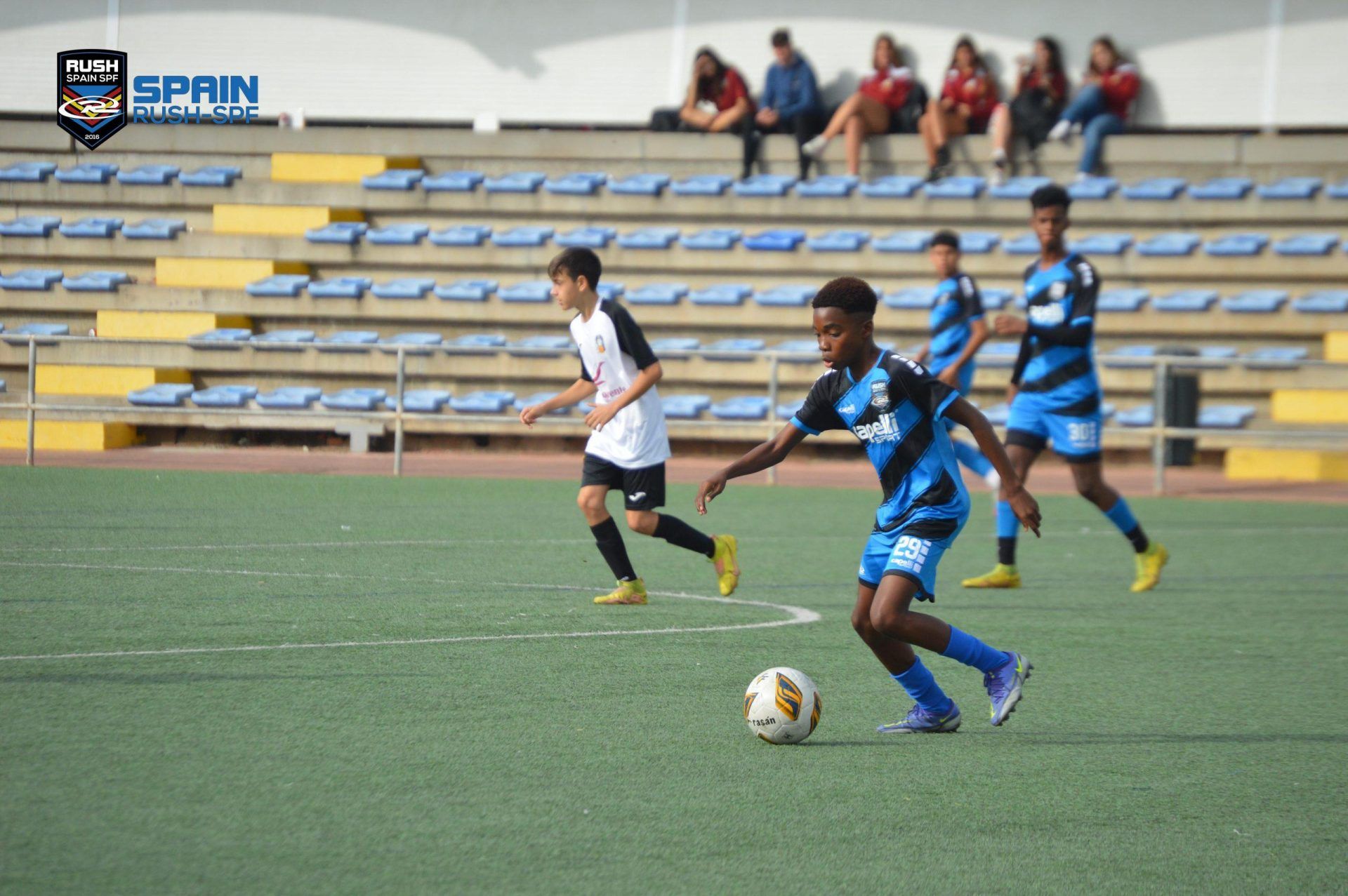 A group of young boys are playing soccer on a field.