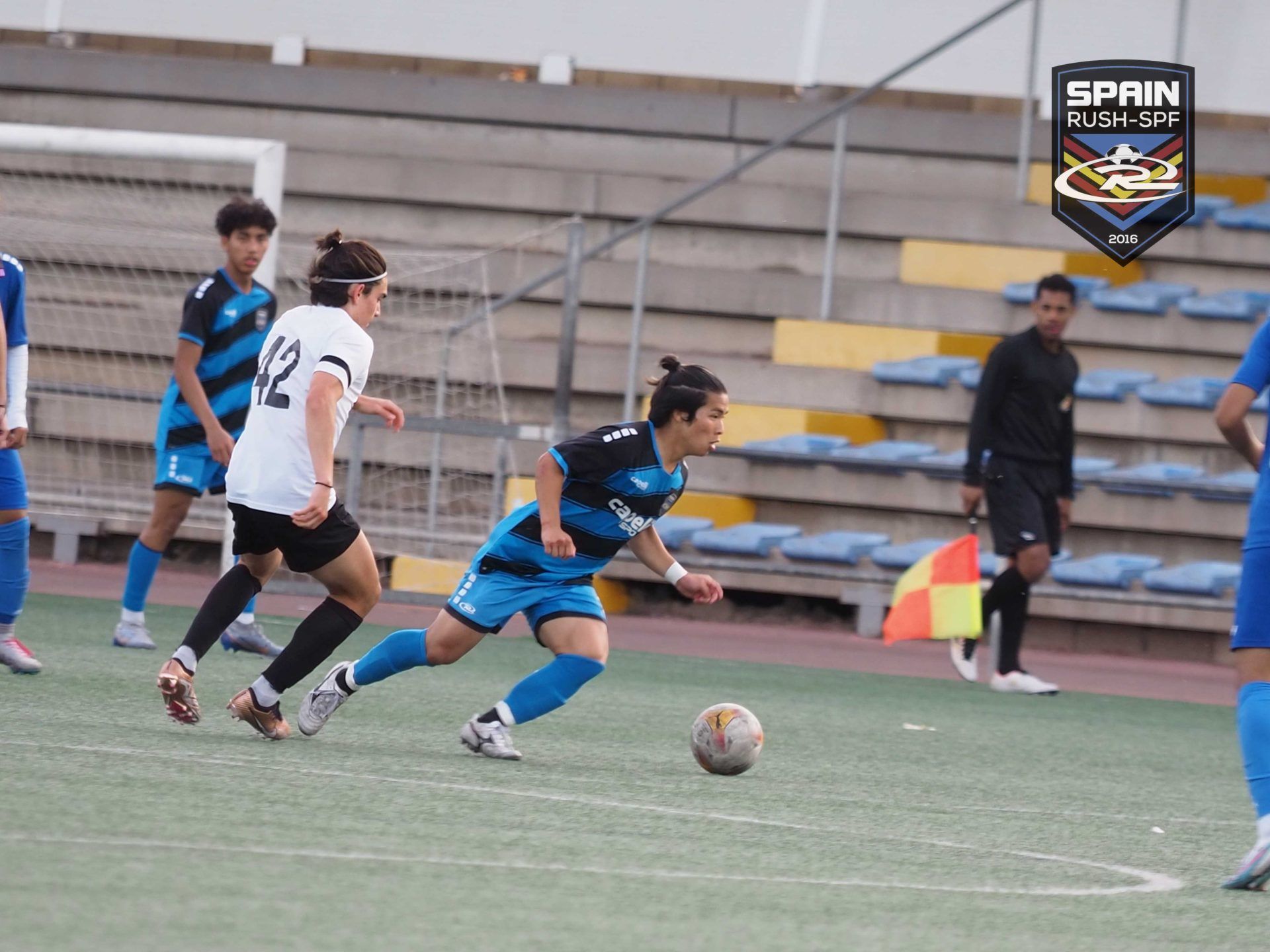 A group of soccer players are playing a game on a field.