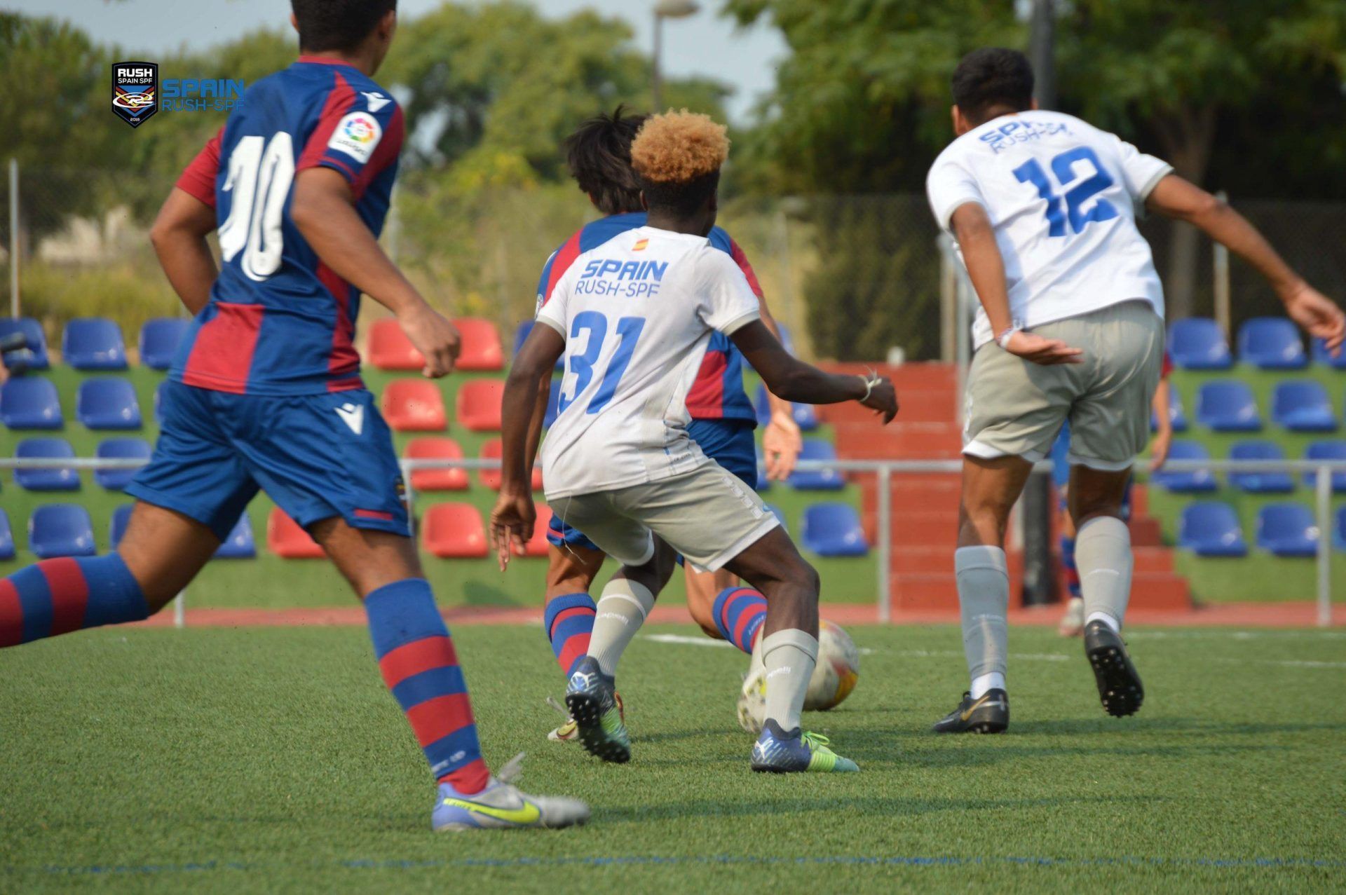 A group of young men are playing soccer on a field.