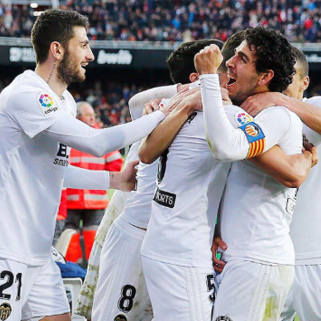 A group of soccer players are hugging each other on a field.