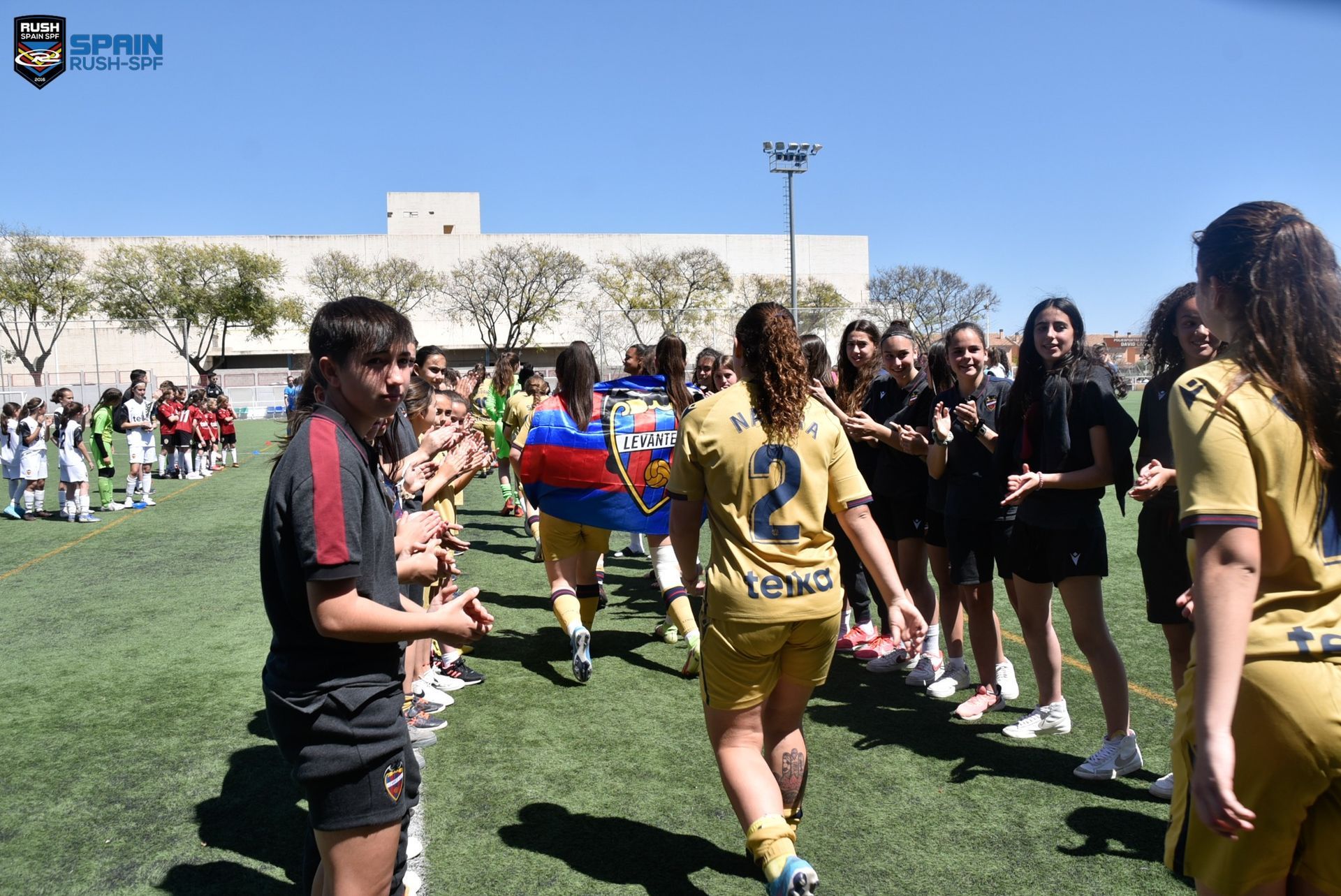 A group of soccer players are walking on a field.