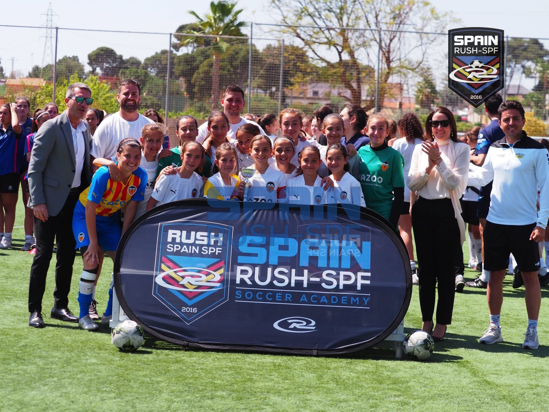 A group of people standing in front of a sign that says spain rush spf