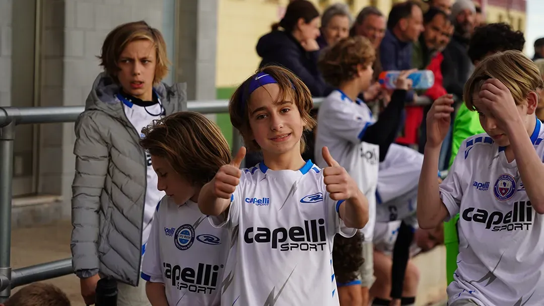 A group of young boys wearing Capelli jerseys are giving a thumbs up.