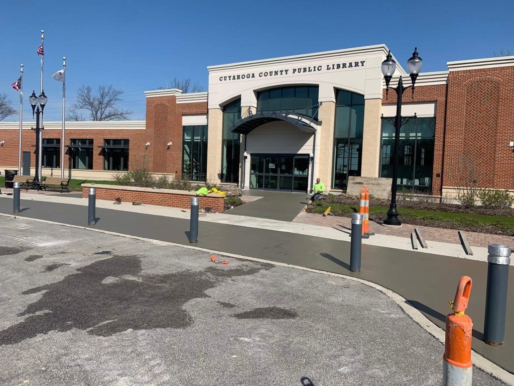 Exterior of the Allen County Public Library branch building with red brick and light-colored trim. Construction cones and bollards are present.