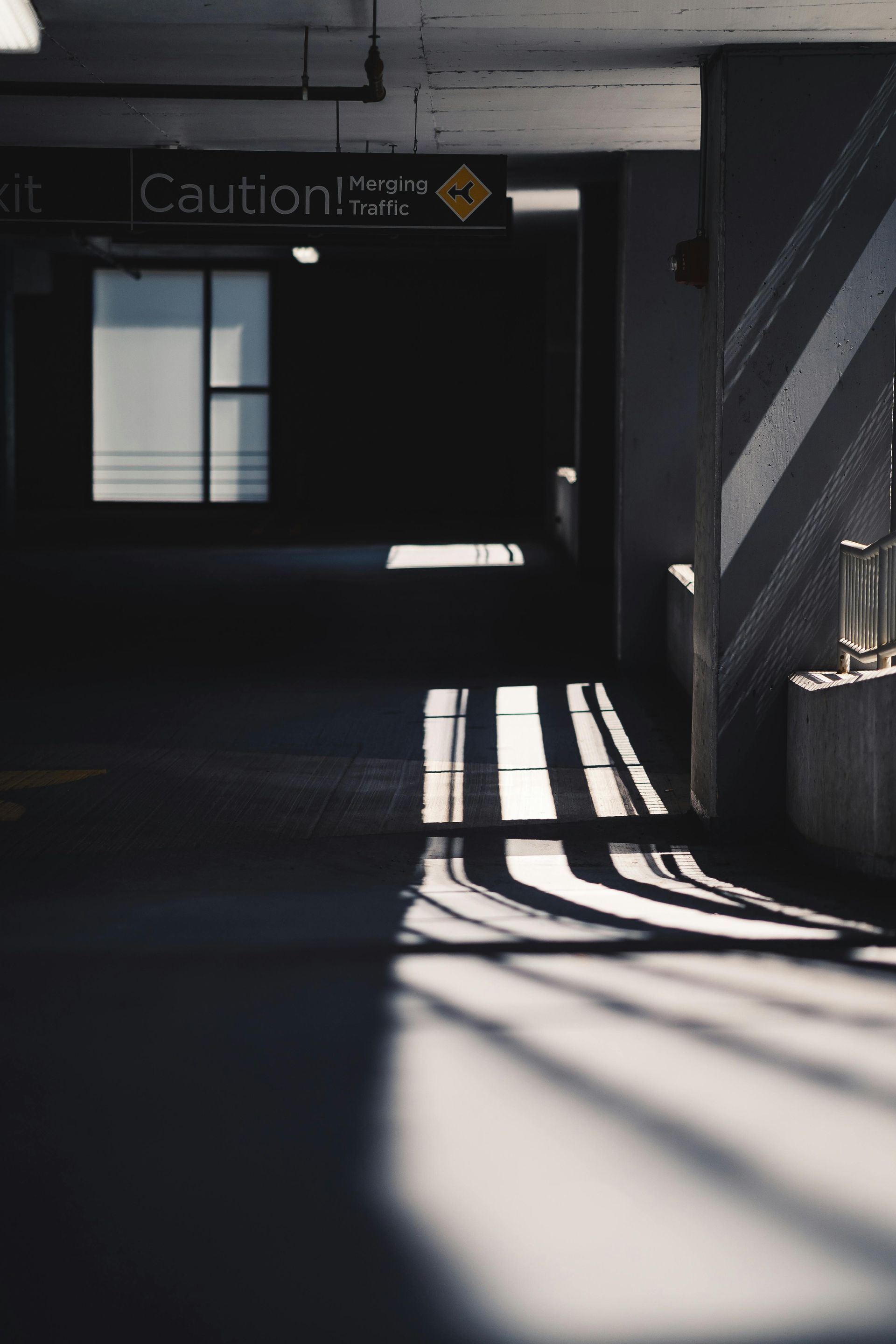 Parking garage entrance with ramp, no entry signs, and yellow safety barriers.