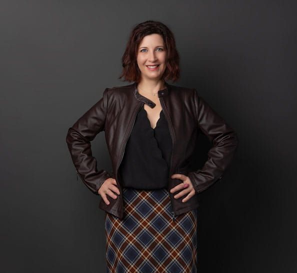 A woman wearing a plaid skirt and a leather jacket