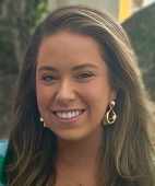 A close up of a woman wearing earrings and smiling.