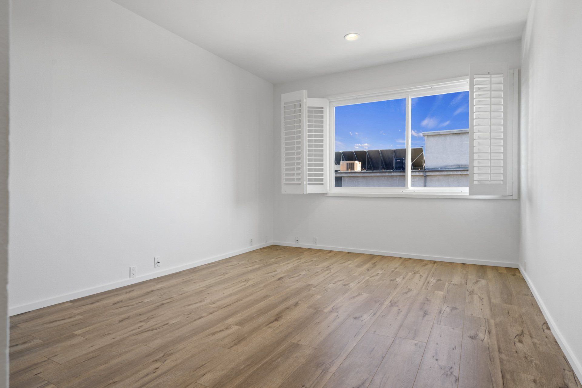 Interior view of bedroom with large window and white walls