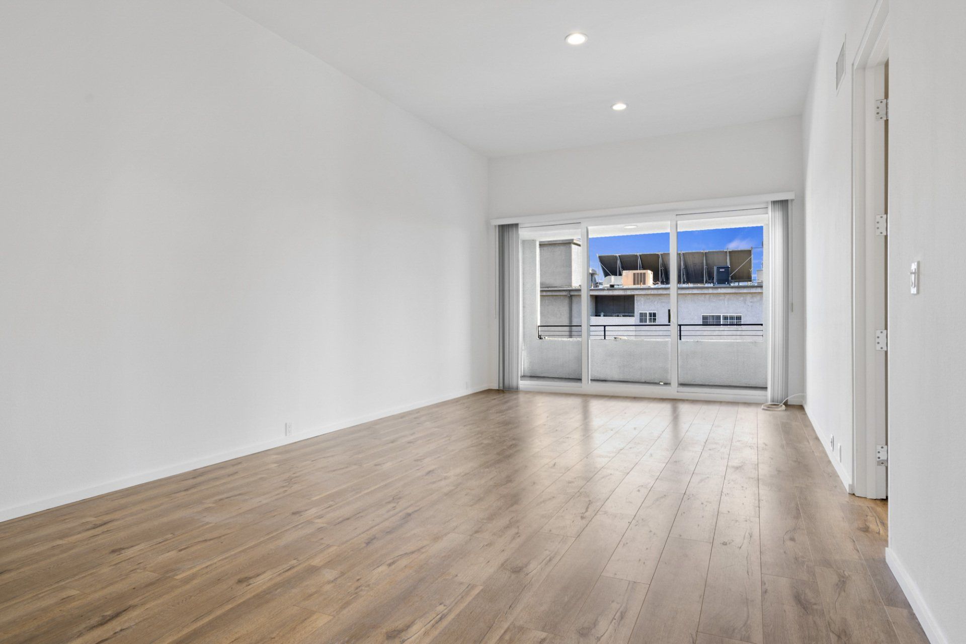 Interior view of room with balcony and glass doors at far end
