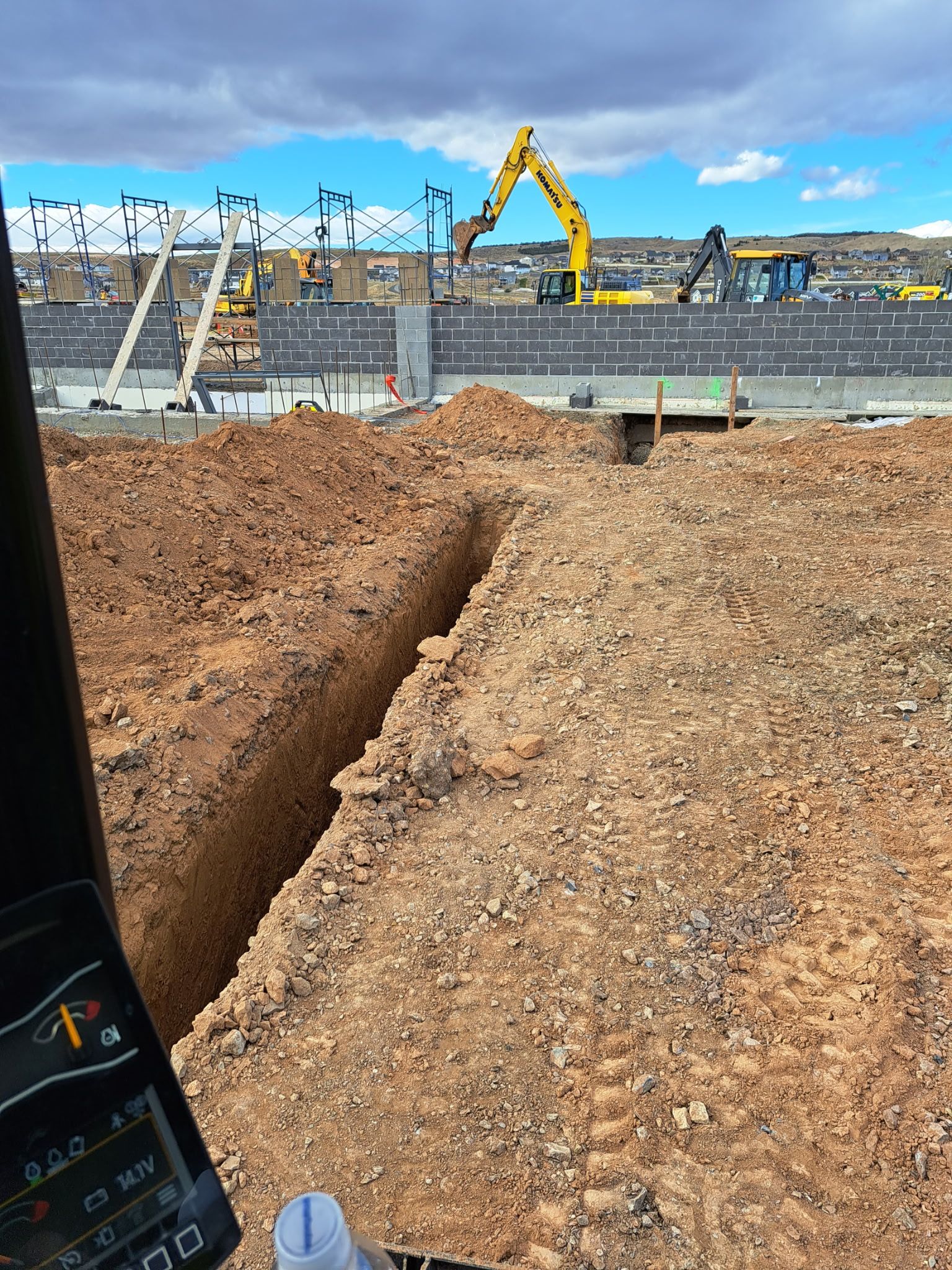 A construction site with a lot of dirt and a phone in the foreground.