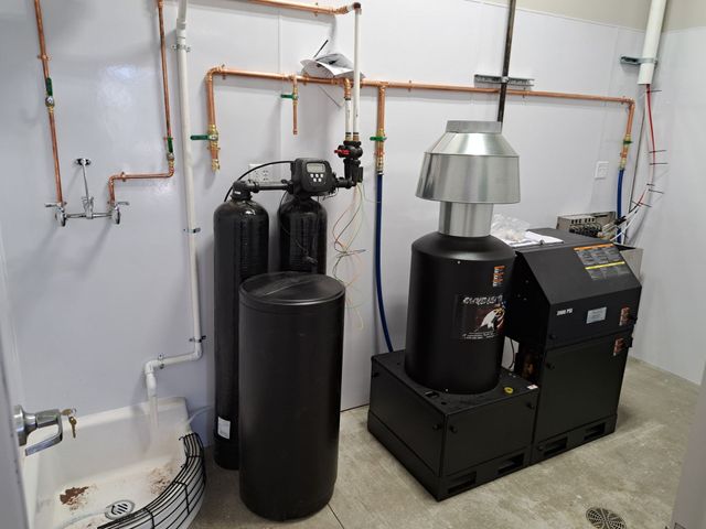 A plumber is fixing a sink in a bathroom.