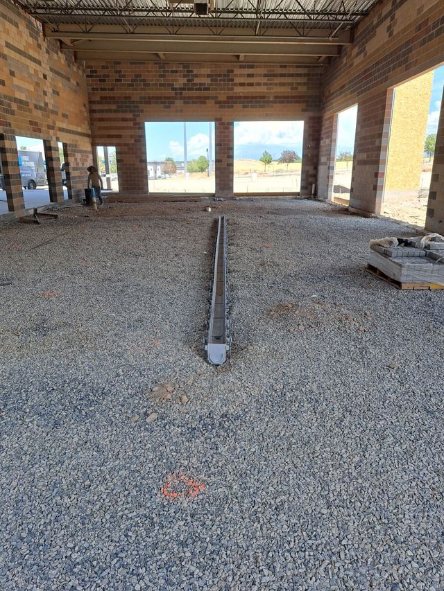 Two engineers are standing on a rooftop looking at a piece of paper.
