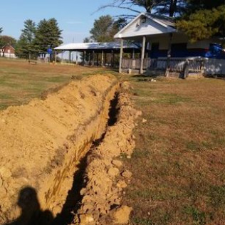 A large pile of dirt is sitting in front of a house.