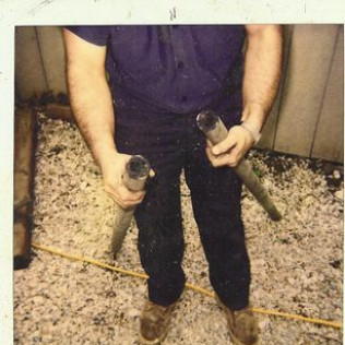 A man in a purple shirt is holding two horns in his hands