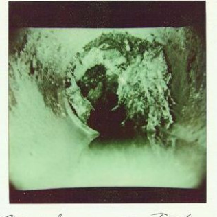 A black and white photo of a person riding a wave