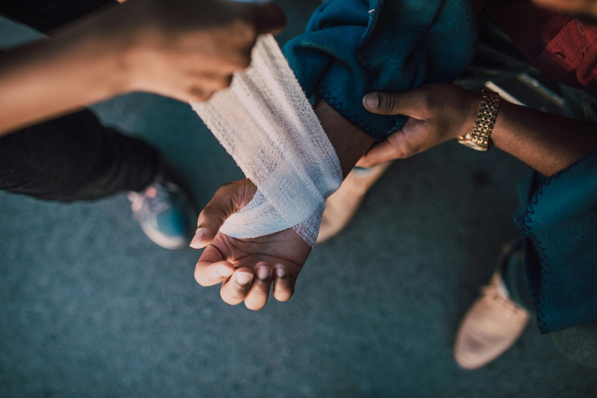 Hands wrapping a white bandage around a wrist in a close-up view