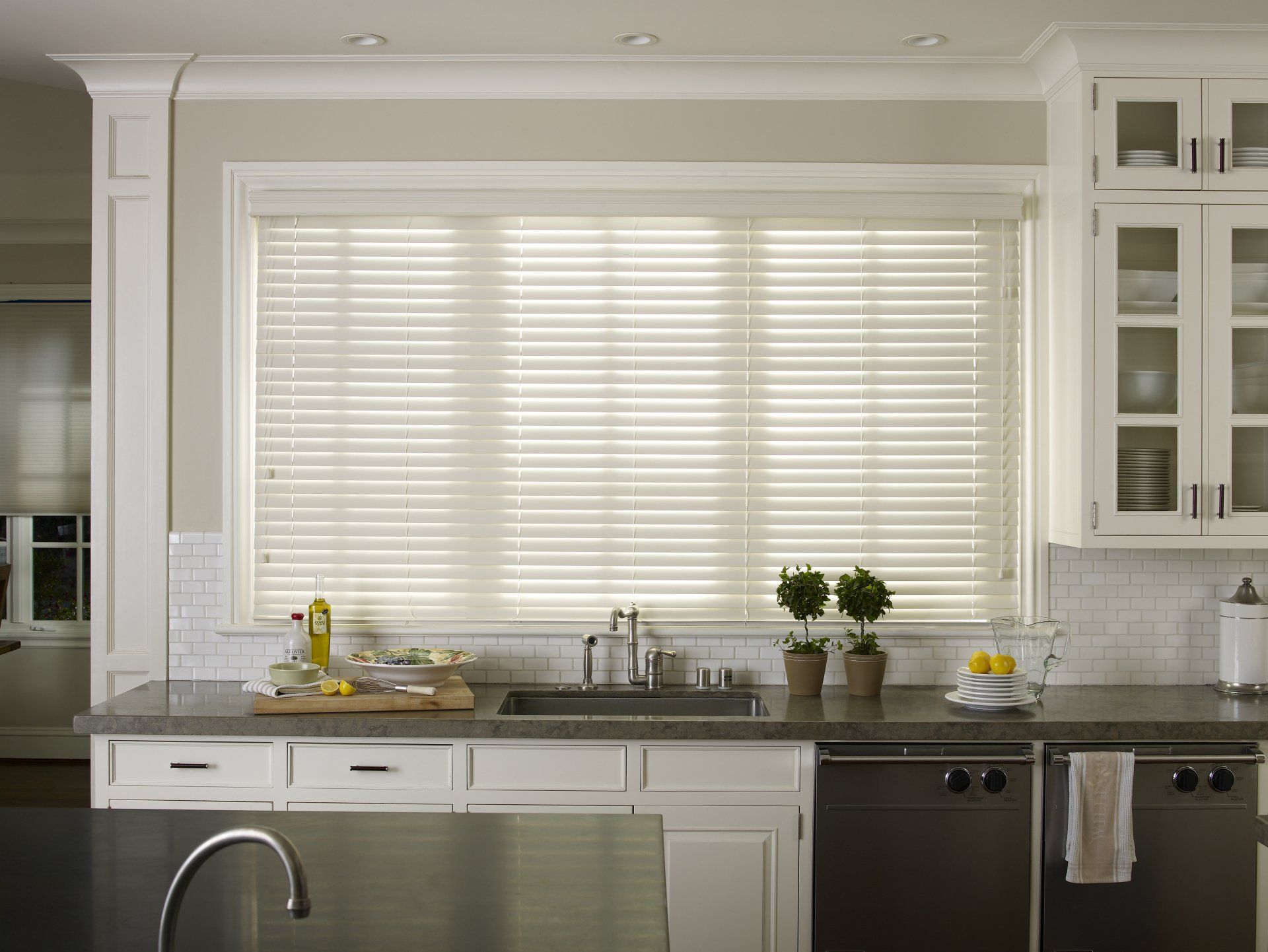 a kitchen with white cabinets and stainless steel appliances window blind solutions Love is Blinds Georgia