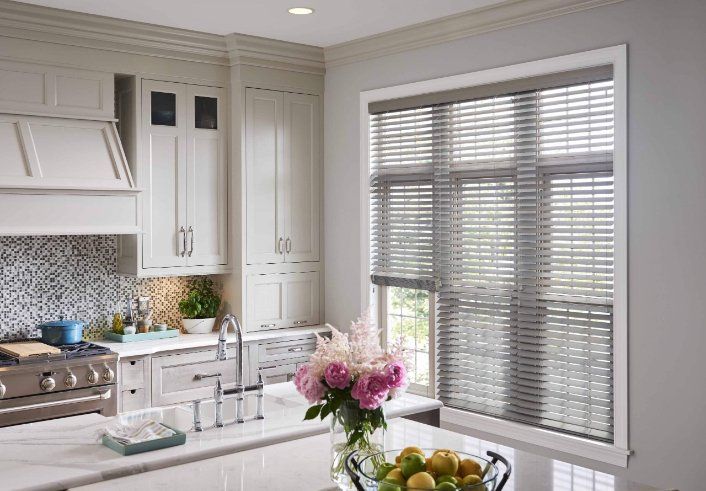 a kitchen with white cabinets , a stove , a sink , and a window with blinds . custom-woven-blinds Love is Blinds Georgia