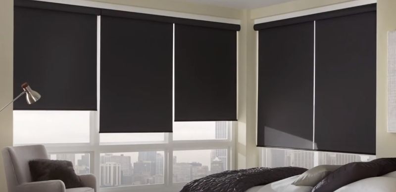 a bedroom with black shades on the windows and a bed roller shades bedroom Love is Blinds Georgia.