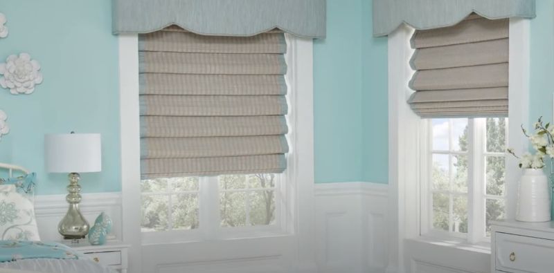 a bedroom with blue walls and cordelss roman shades solutions on the windows Love is Blinds Georgia.