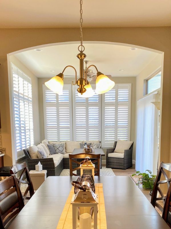 a dining room with a table and chairs and a chandelier window-shutter-solutions-in-Love is Blinds Georgia