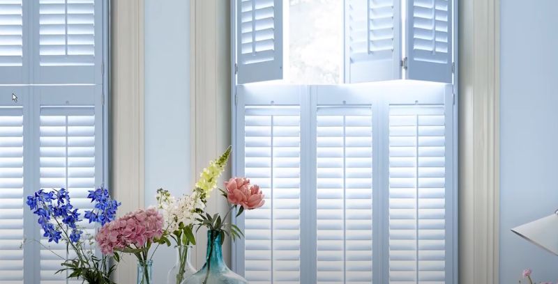 a vase of flowers is sitting in front of a window with white shutters tier on tier shutter solutions Love is Blinds Georgia.