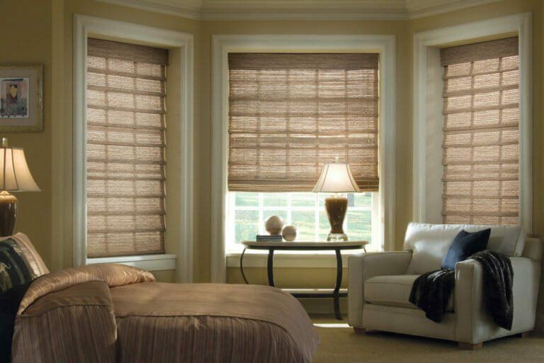 a bedroom with a bed a chair and a table Woven wood shades bedroom Love is Blinds Georgia