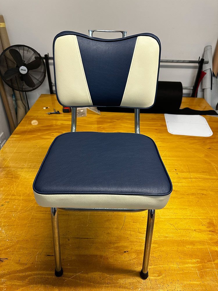 A Blue and White Chair is on a Wooden Table — Paulie's Upholstery in Cairns, QLD