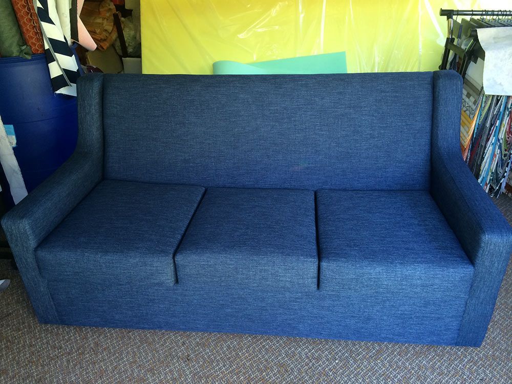 A Blue Couch is on a Carpet in a Room — Paulie's Upholstery in Cairns, QLD